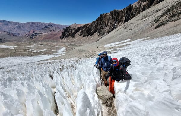 Bergsteiger auf einer Akklimatisationstour am Aconcagua inmitten von Büsserschnee