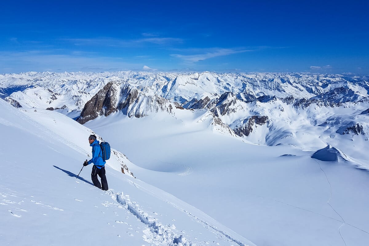Skitourengänger zwischen Binntal Schweiz und Alpe Devero Italien mit Fernsicht in verschneite Berge