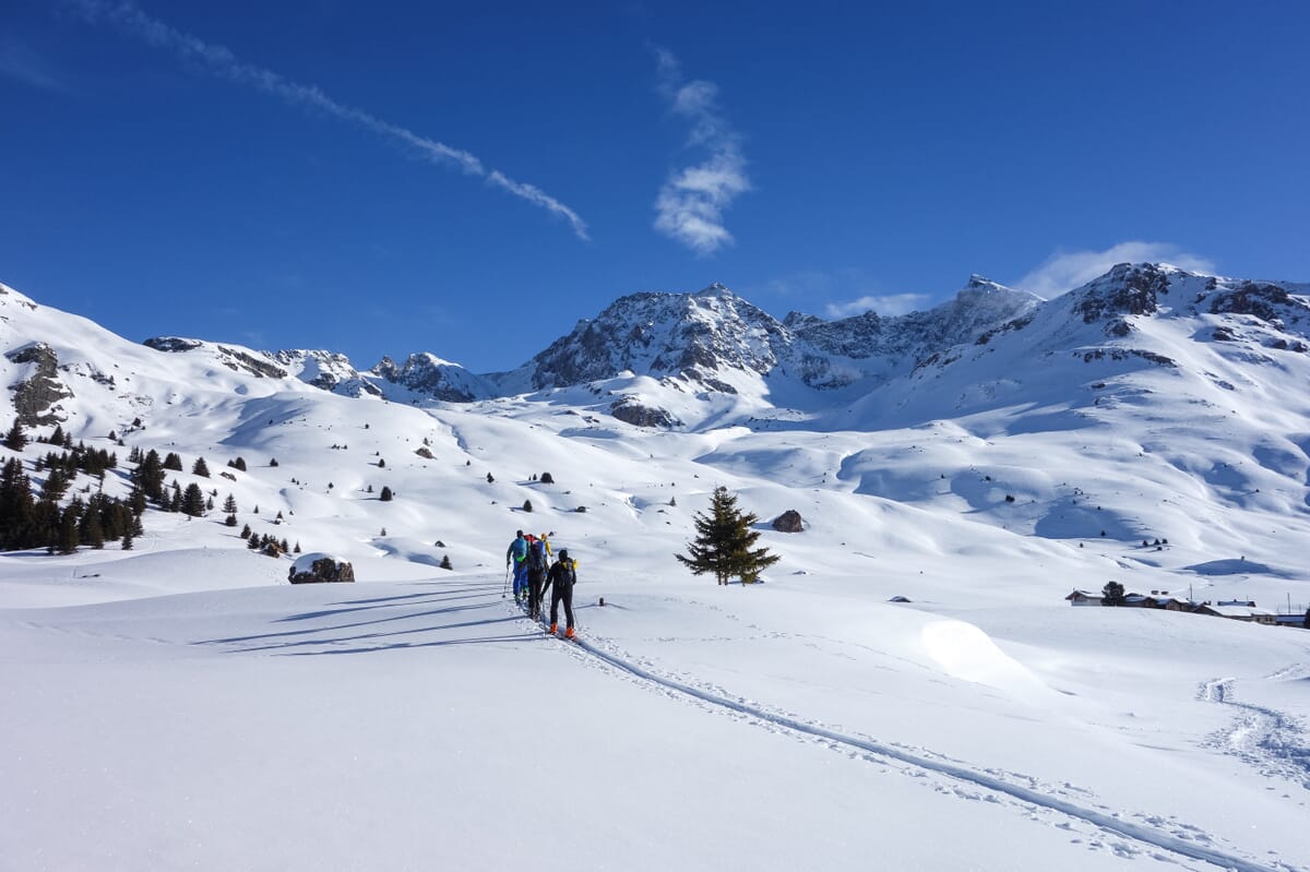Skitourengeher:innen während dem Aufstieg in verschneiter Winterlandschaft
