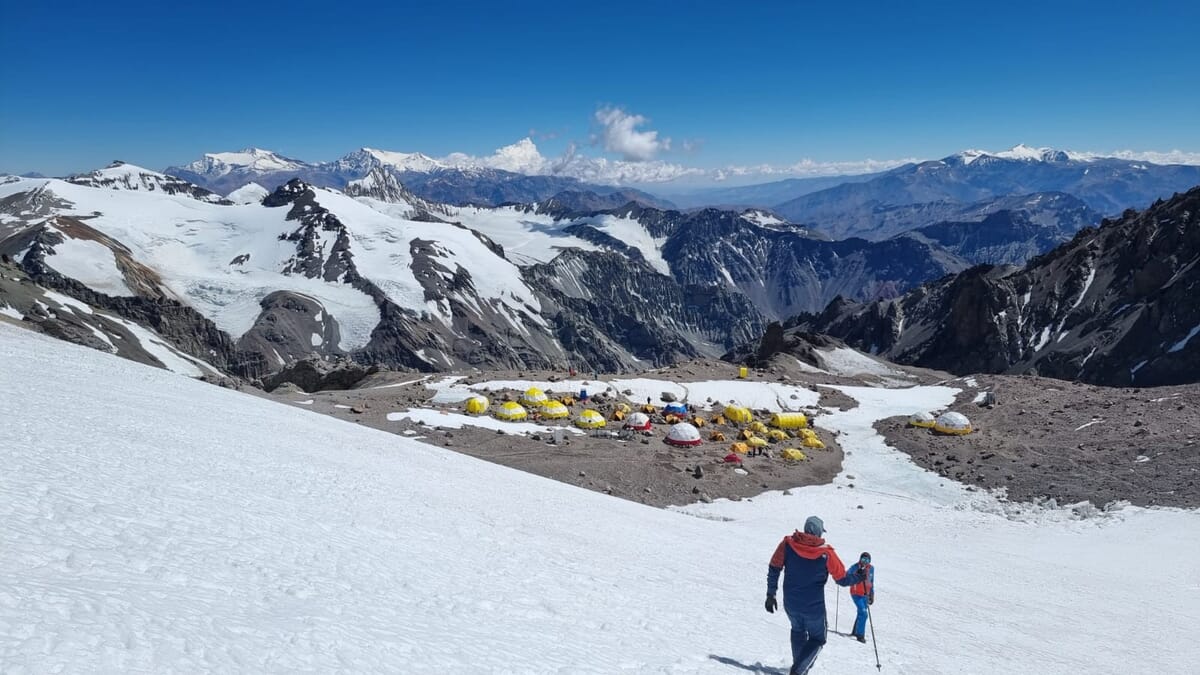Zwei Bergsteiger auf dem Weg ins Basecamp, gelbe Expeditionszelte, Firnfeld