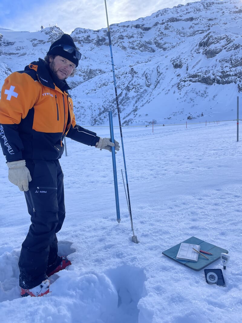 Julian macht Messungen im Schnee, Notizblock, Sonde, Lupe 