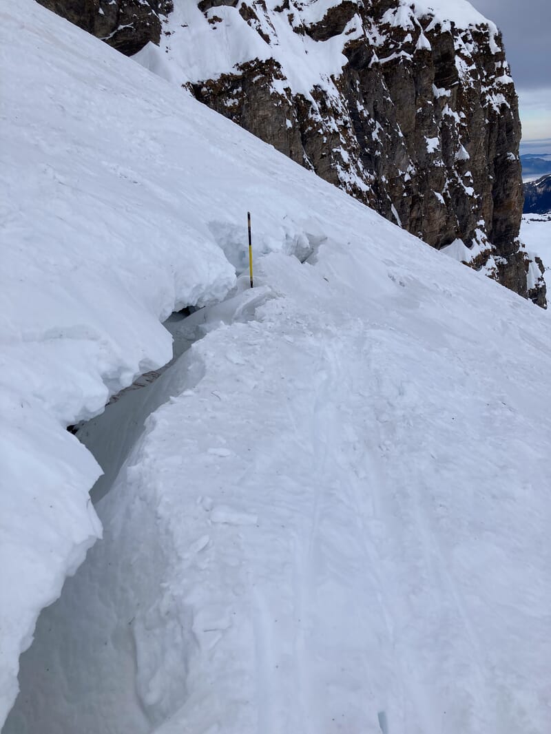 Ein Riss in der Schneedecke wird analysiert, Lawinengefahr wird eingeschätzt