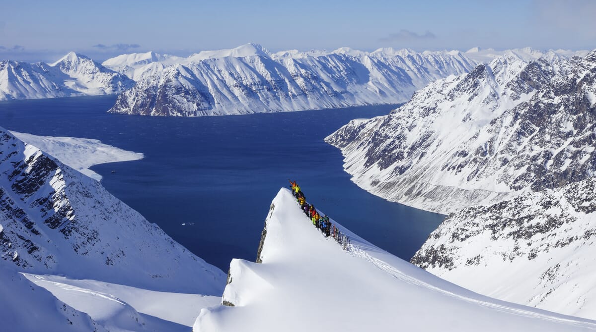 Skitourengruppe auf Gipfel im hohen Norden mit Berg+Tal