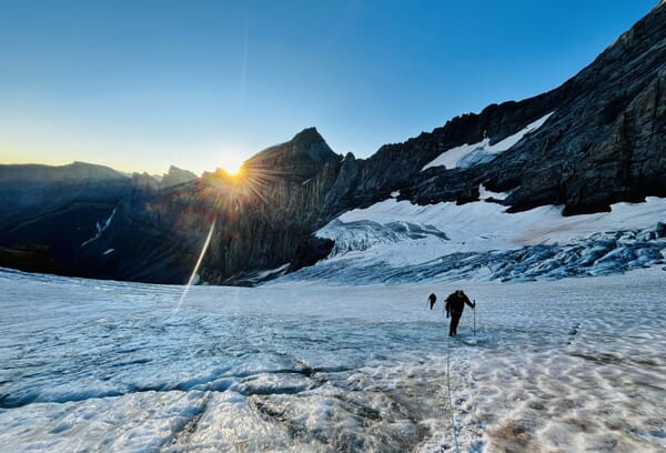 Bergsteiger auf Gletscher bei Sonnenaufgang.