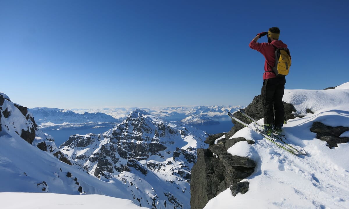 Skitourengeher in Norwegen, geniesst Aussicht über Berge und Fjorde