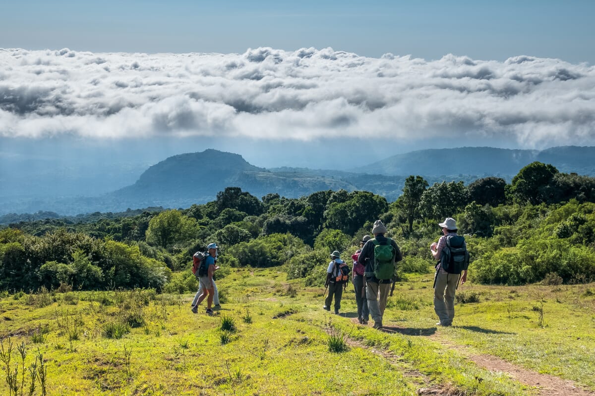 Wanderer auf Weg mit Bergen und Wolken