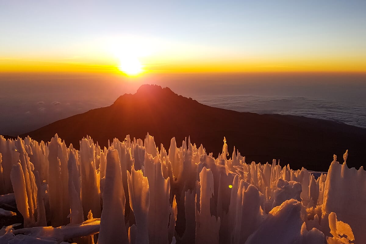Sonnenaufgang über Berg und Eisformationen.