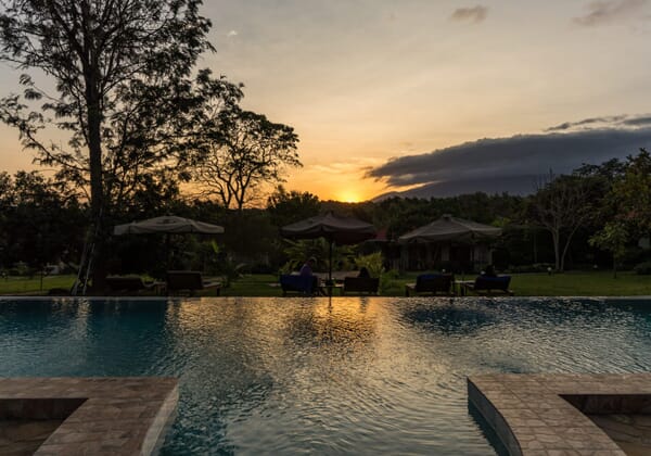 Sonnenuntergang über einem Pool im Garten.