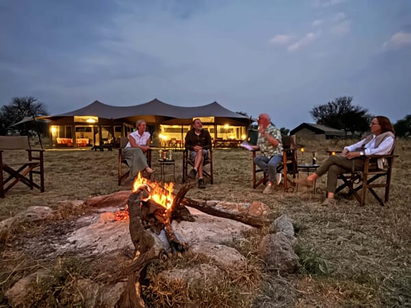 Gruppe am Lagerfeuer vor Zelt in Savanne