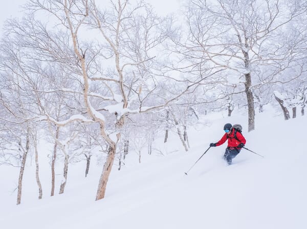 Skifahrer im roten Anzug im verschneiten Gelände Japans