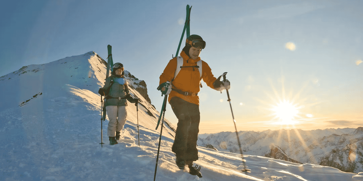 Zwei Tourengänger auf einem Grat, Ski auf den Rucksack gebunden, Skitouren