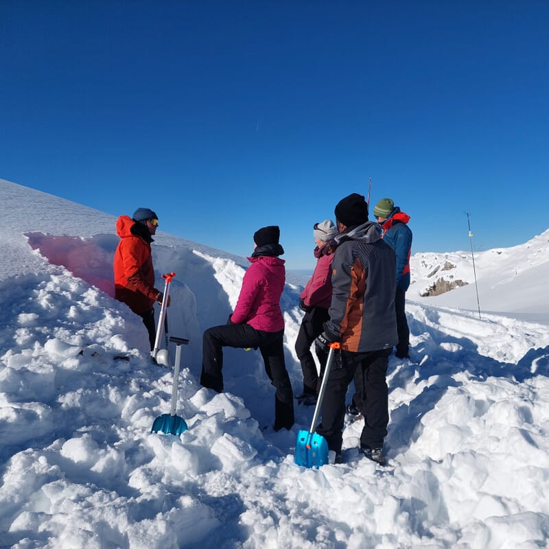 Es wird ein Loch gegraben um ein Schneeprofil zu machen, Lawinenkurs