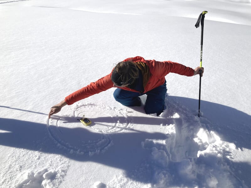 Grundkurs Lawinen, Bergführer zeichnet die magnetischen Feldlinien in den Schnee